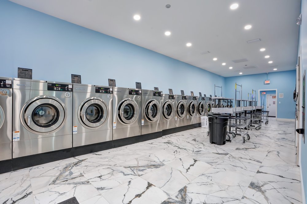 Long row of commercial washers inside Sac O Suds